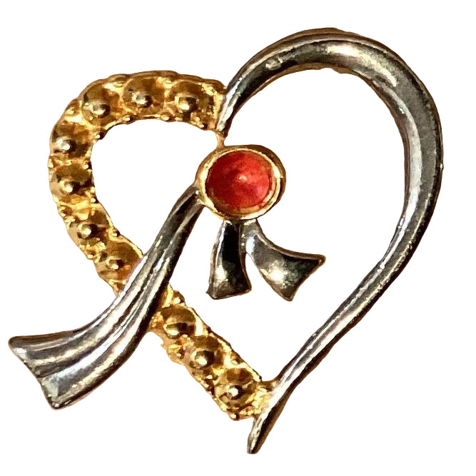Gold and silver heart-shaped brooch with red ruby accents, featuring intricate jewelry design and metalwork.