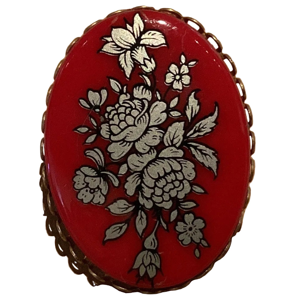Vintage burgundy resin brooch with silver-tone floral bouquet and ornate scalloped metal frame, 1.75 inches in size.