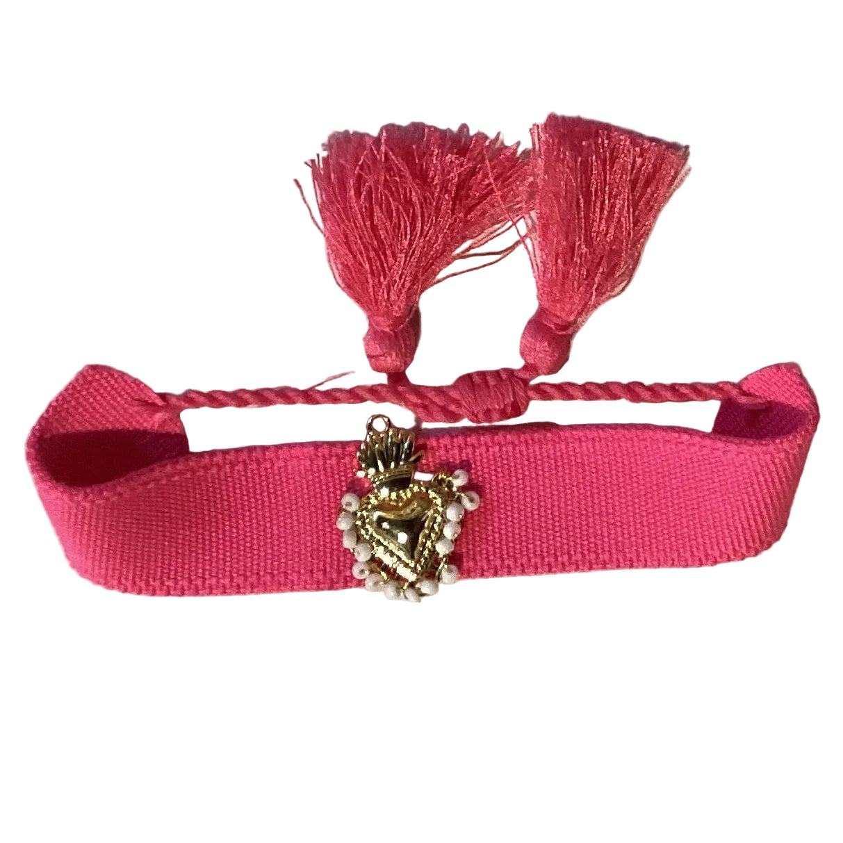Pink woven Sacred Heart bracelet with hand-beaded centerpiece, adjustable cord, tassel ends, and white beads, featuring Catholic religious design.