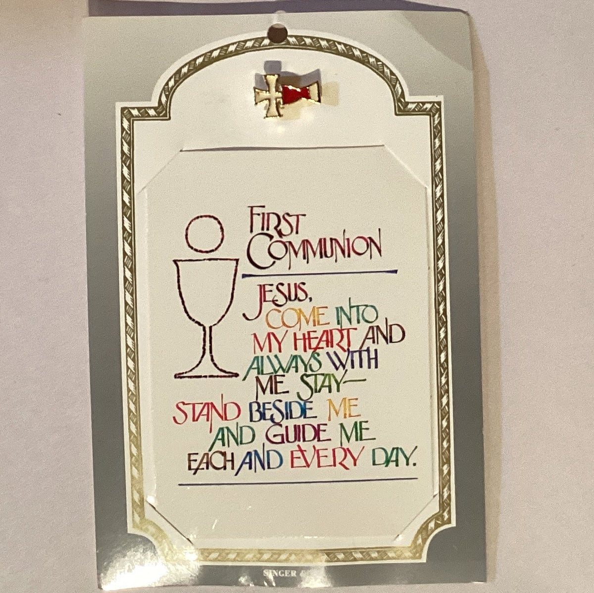 First Communion & Confirmation prayer card with Catholic lapel pin featuring religious symbols and Christian devotional accessories.
