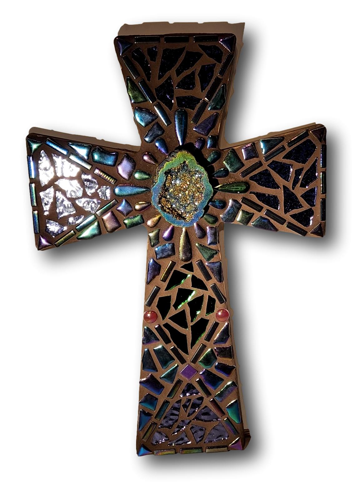 mosaic cross with iridescent pieces and glass and geode in middle on wood