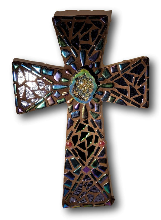 mosaic cross with iridescent pieces and glass and geode in middle on wood