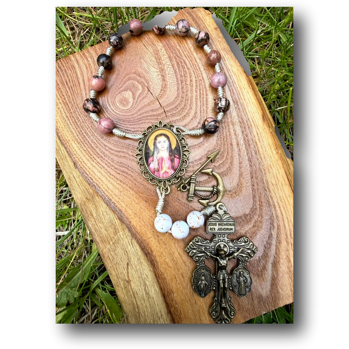 Saint Philomena Rhodonite Catholic chaplet with arrow and anchor beads, featuring a Liza Murphy logo on the rosary.
