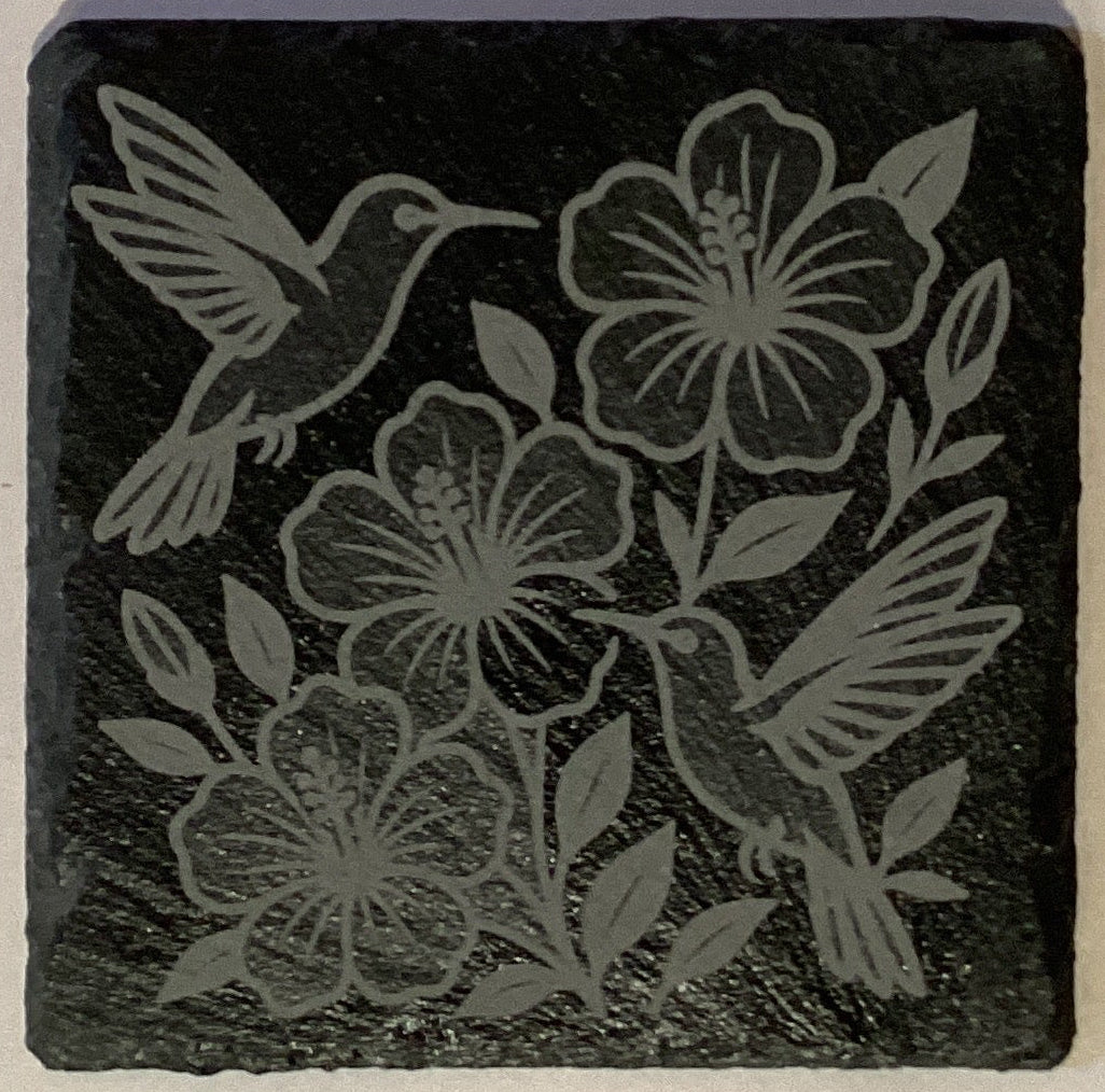 Set of four etched slate coasters with assorted designs, 4x4 inches, featuring natural stone texture and decorative patterns.