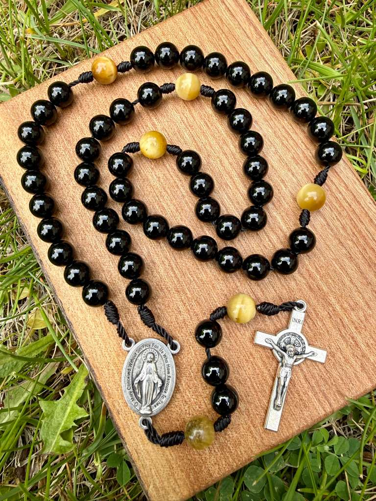 Catholic rosary with black agate and golden tiger’s eye beads, Miraculous Medal centerpiece, Saint Benedict crucifix, five-decade design.