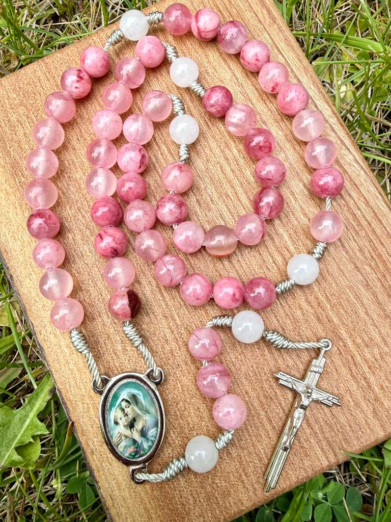 Pink jade Marian Catholic rosary with ornate centerpiece and five decades, featuring pink jade beads and detailed Christian religious design.