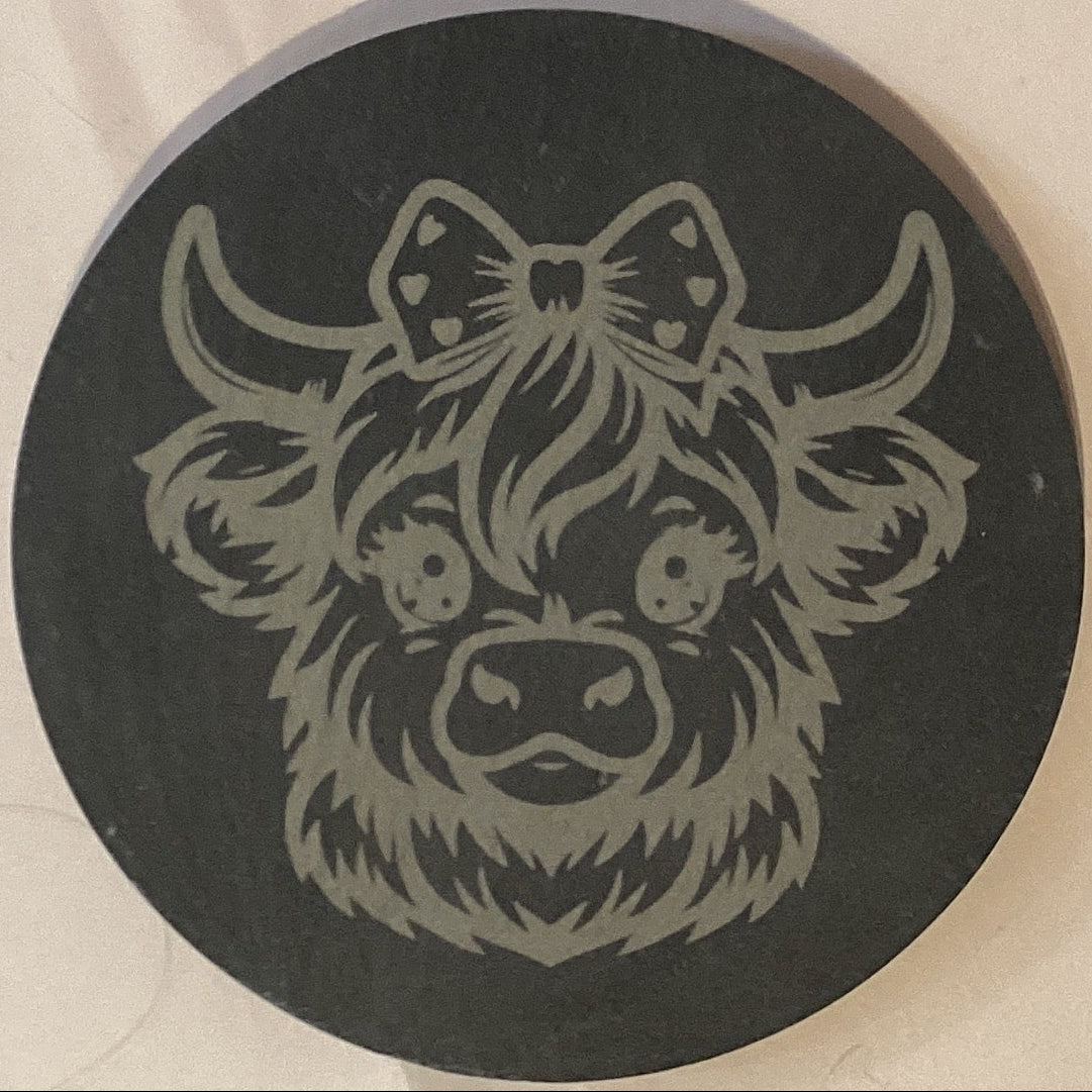 Cow design stone coasters, 4-inch size from Ysleta Mission Gift Shop featuring rustic cow illustrations on natural stone surfaces.