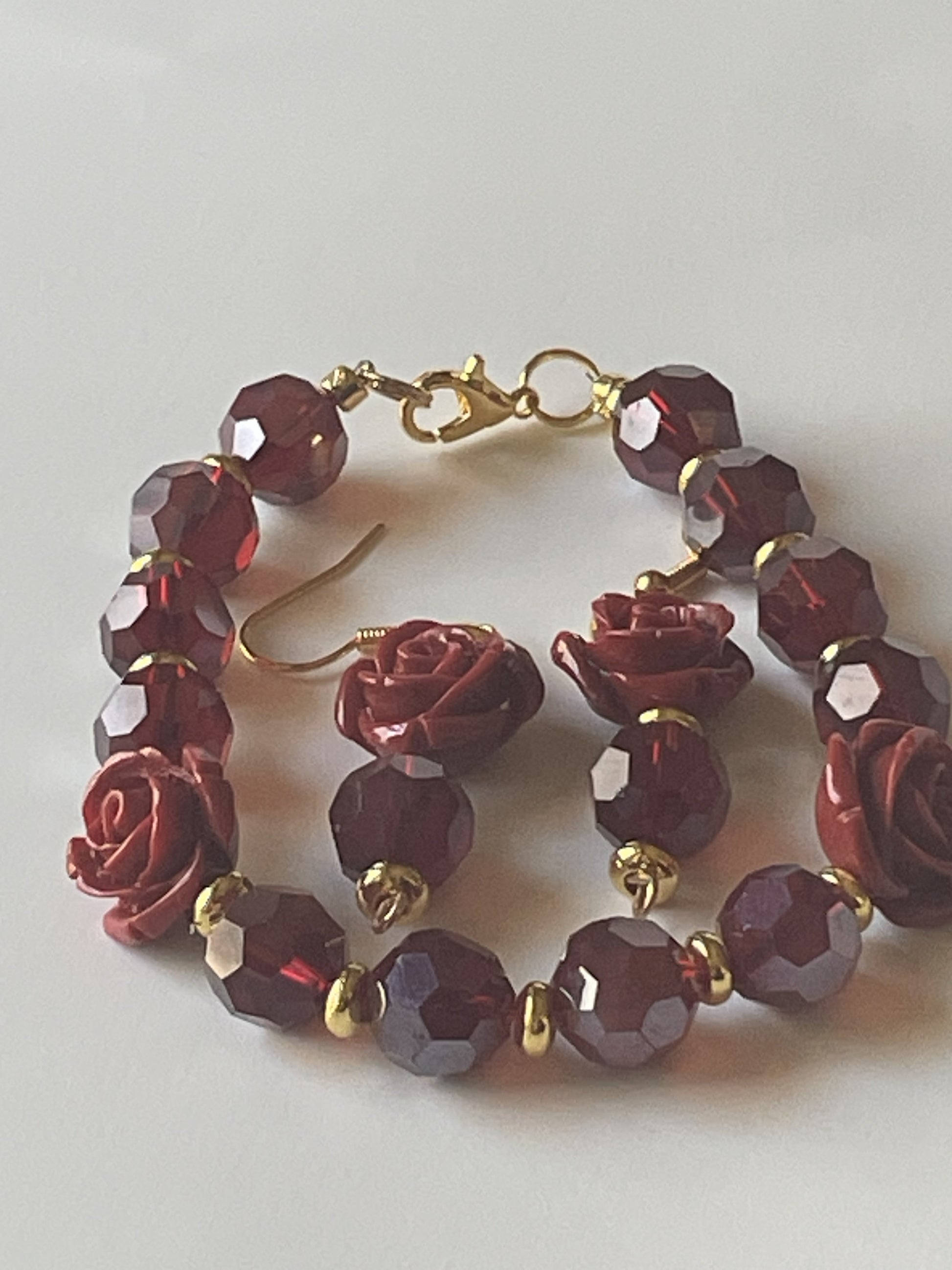 Wine-colored faceted bead bracelet with matching 2-inch dangle earrings, Sylvia Leroux jewelry set featuring gold accents and rose resin beads.