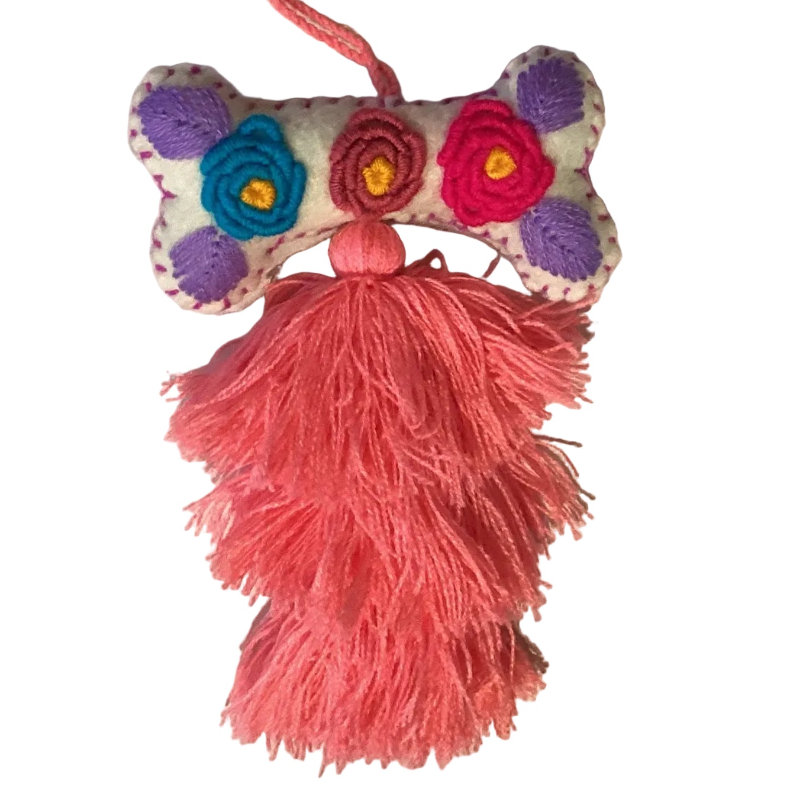 Handcrafted Mexican embroidered dog bone charm tassel accessory by Jose Alberto Chavez, featuring colorful embroidery and artisan details.