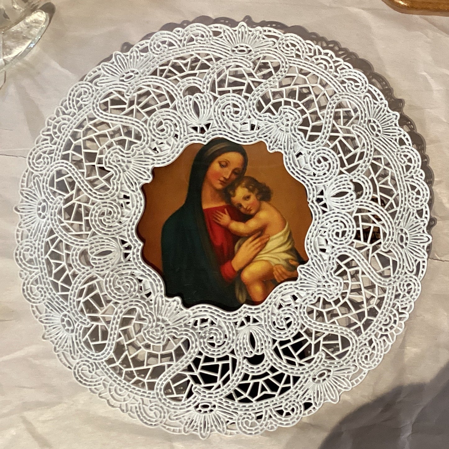 Mary with Baby Jesus figurine in a 20-inch metal doily-style frame, showcasing detailed religious artwork.