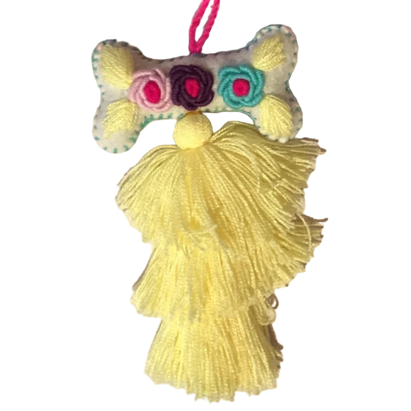 Handcrafted Mexican embroidered dog bone charm tassel accessory by Jose Alberto Chavez, featuring colorful embroidery and artisan details.