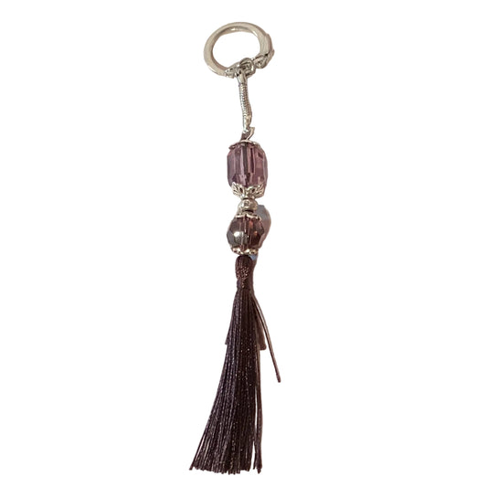 Purple crystal keychain with tassel, snap hook, and snake link, featuring a decorative and sparkling accessory from Ysleta Mission Gift Shop.