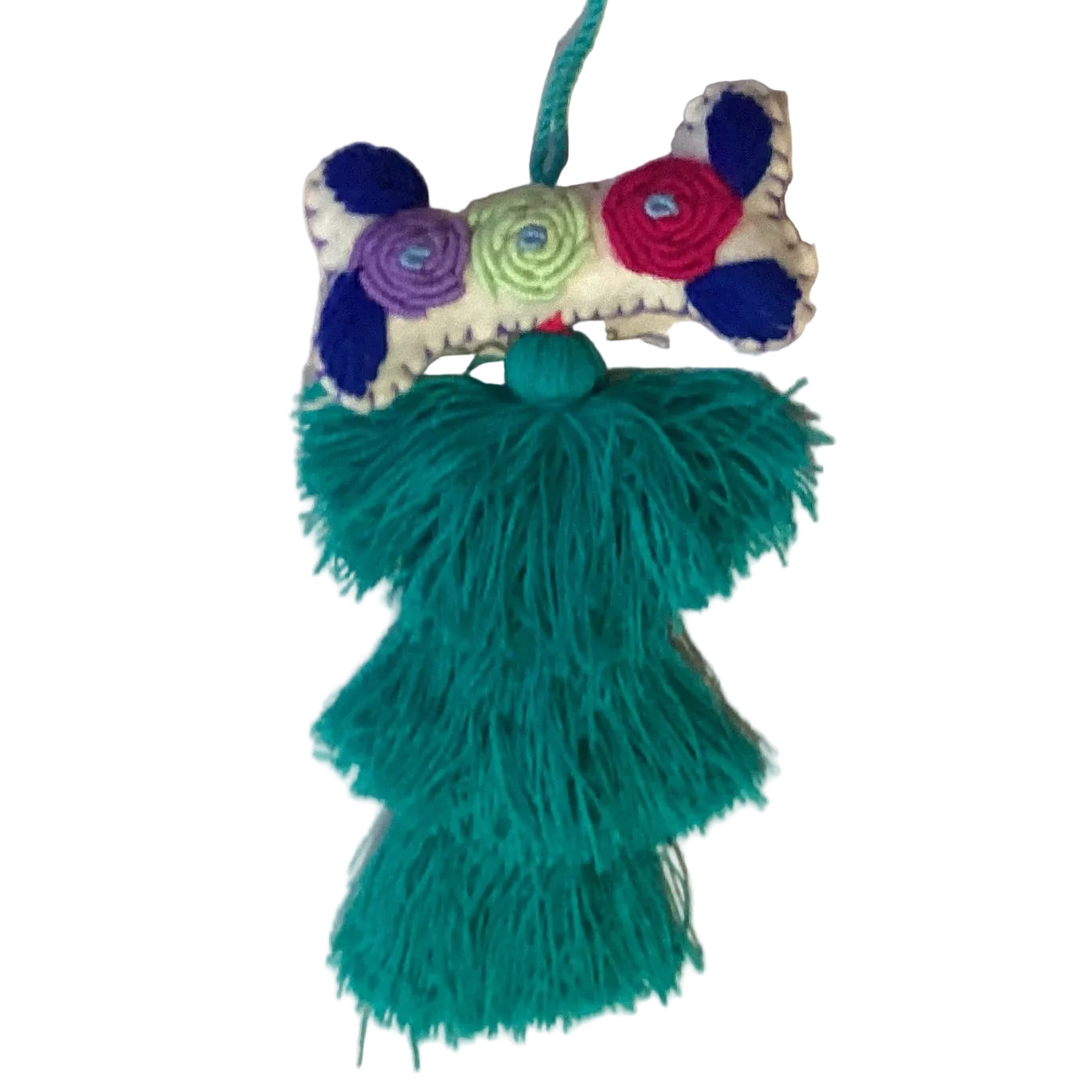 Handcrafted Mexican embroidered dog bone charm tassel accessory by Jose Alberto Chavez, featuring colorful embroidery and artisan craftsmanship.