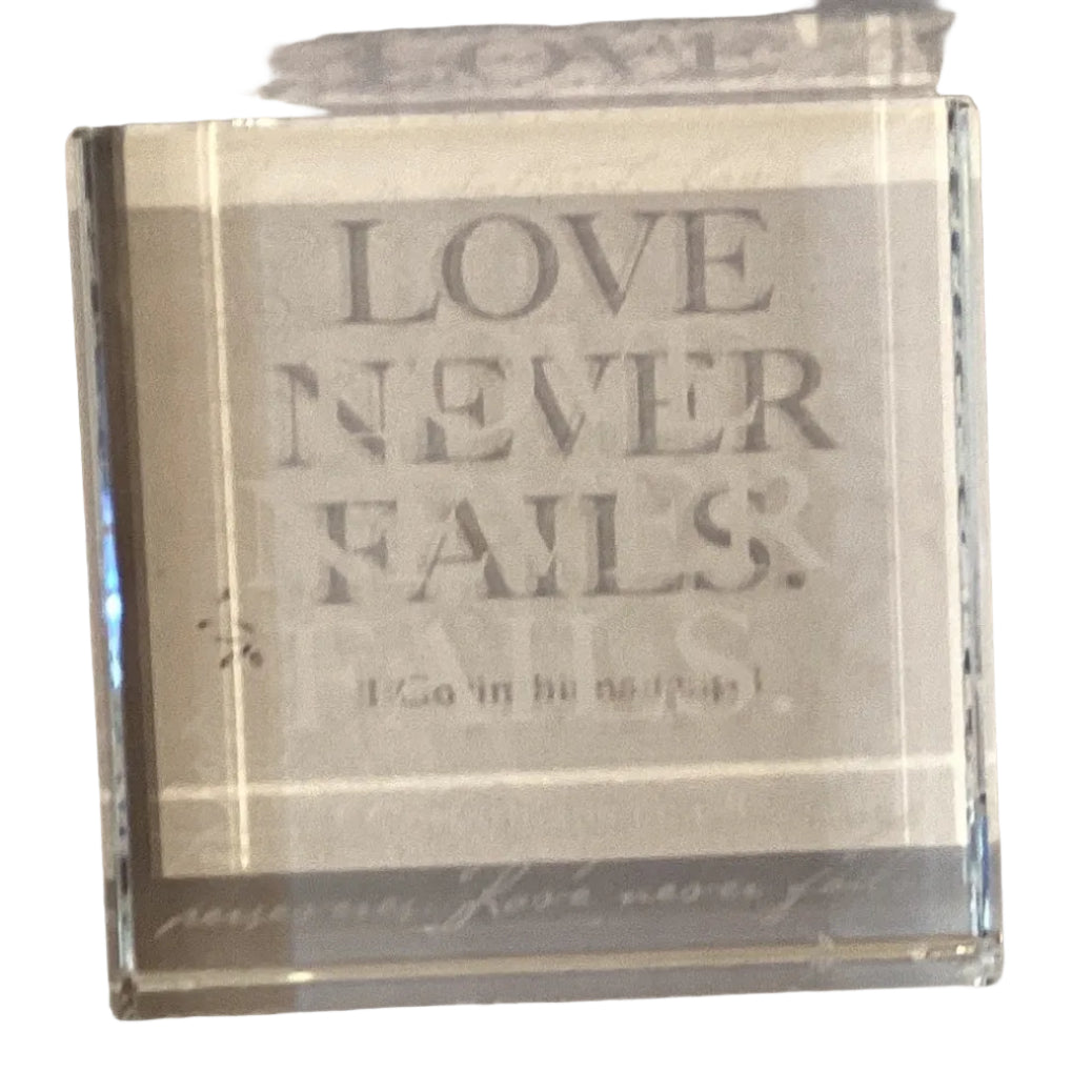 Crystal plaque with "Love Never Fails" inscription, featuring a 3-inch size and elegant design from Ysleta Mission Gift Shop.