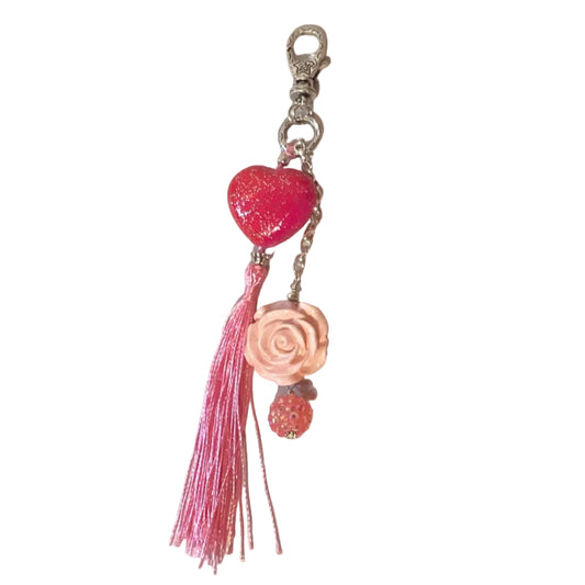 Pink heart keychain with rose charm and tassel, featuring a lobster clasp, from Ysleta Mission Gift Shop.