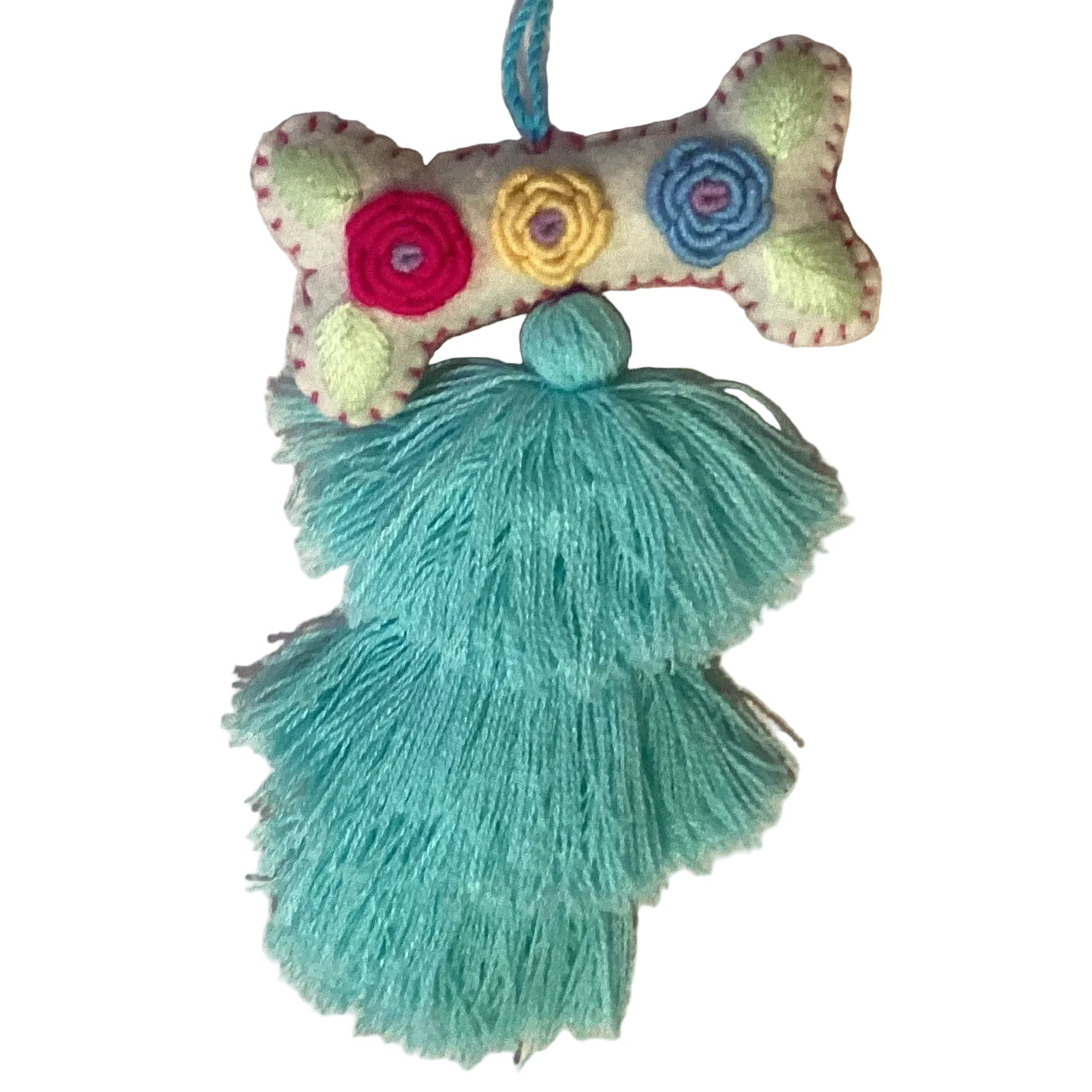 Handcrafted Mexican embroidered dog bone charm with tassel, artisan accessory from Jose Alberto Chavez for bag decoration.