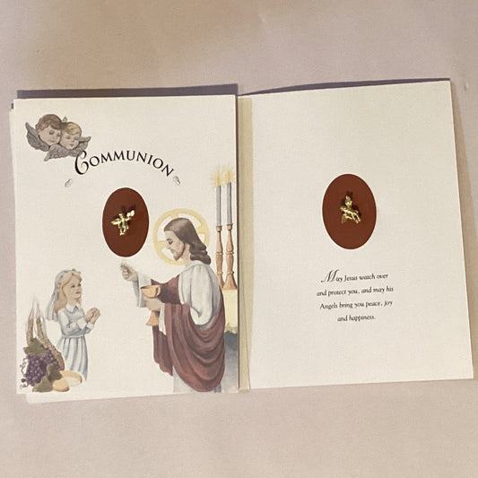 First Communion Catholic card featuring an angel keepsake pin, with religious imagery and Christian greeting details.