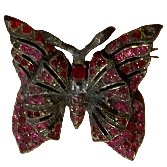 Silver butterfly brooch with pink gemstones, Catholic Christian jewelry piece featuring delicate metalwork and vibrant stone accents.