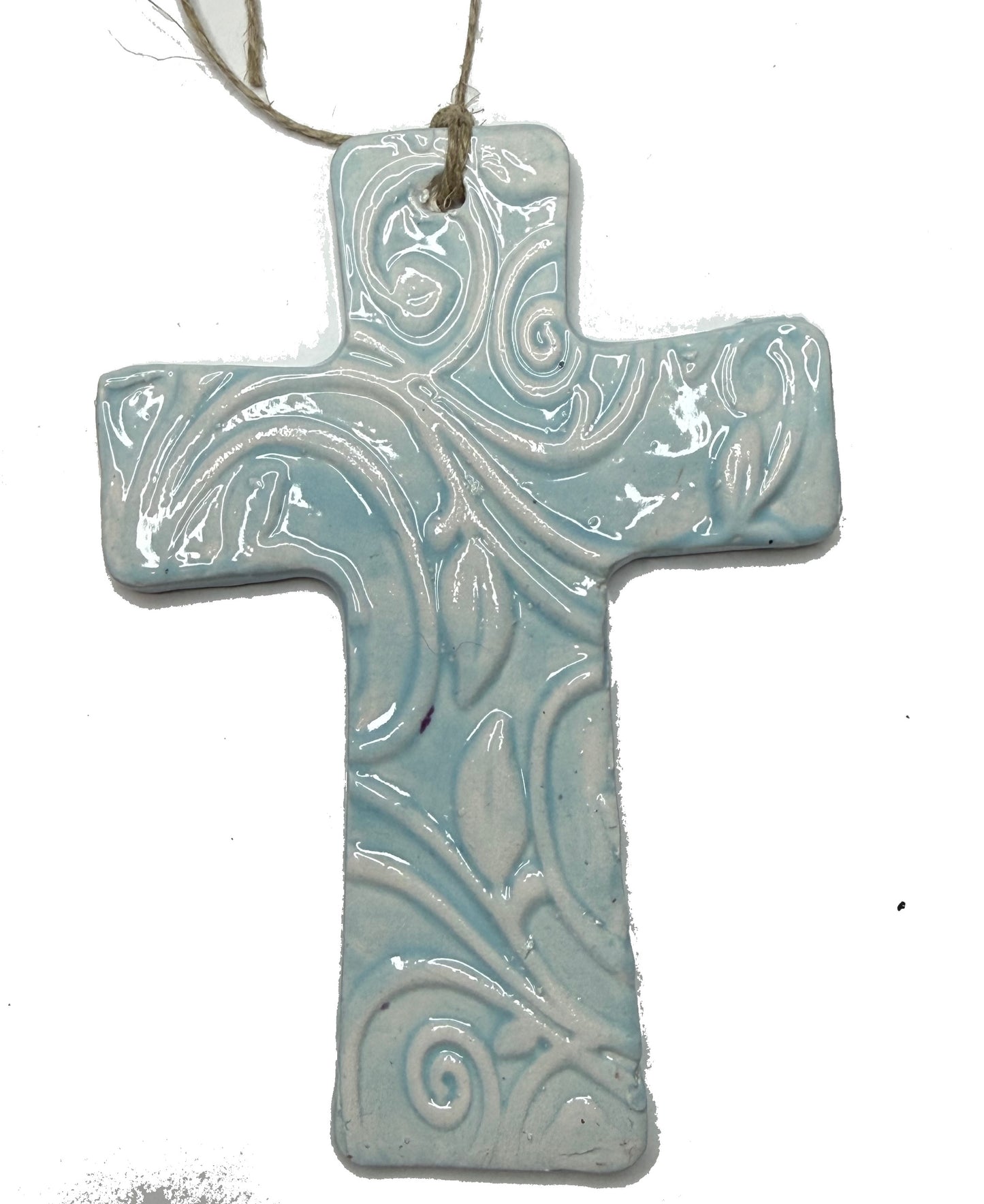 Light blue ceramic cross sculpture by Lorena Williams with smooth finish and detailed design, ideal for home decor or spiritual space.