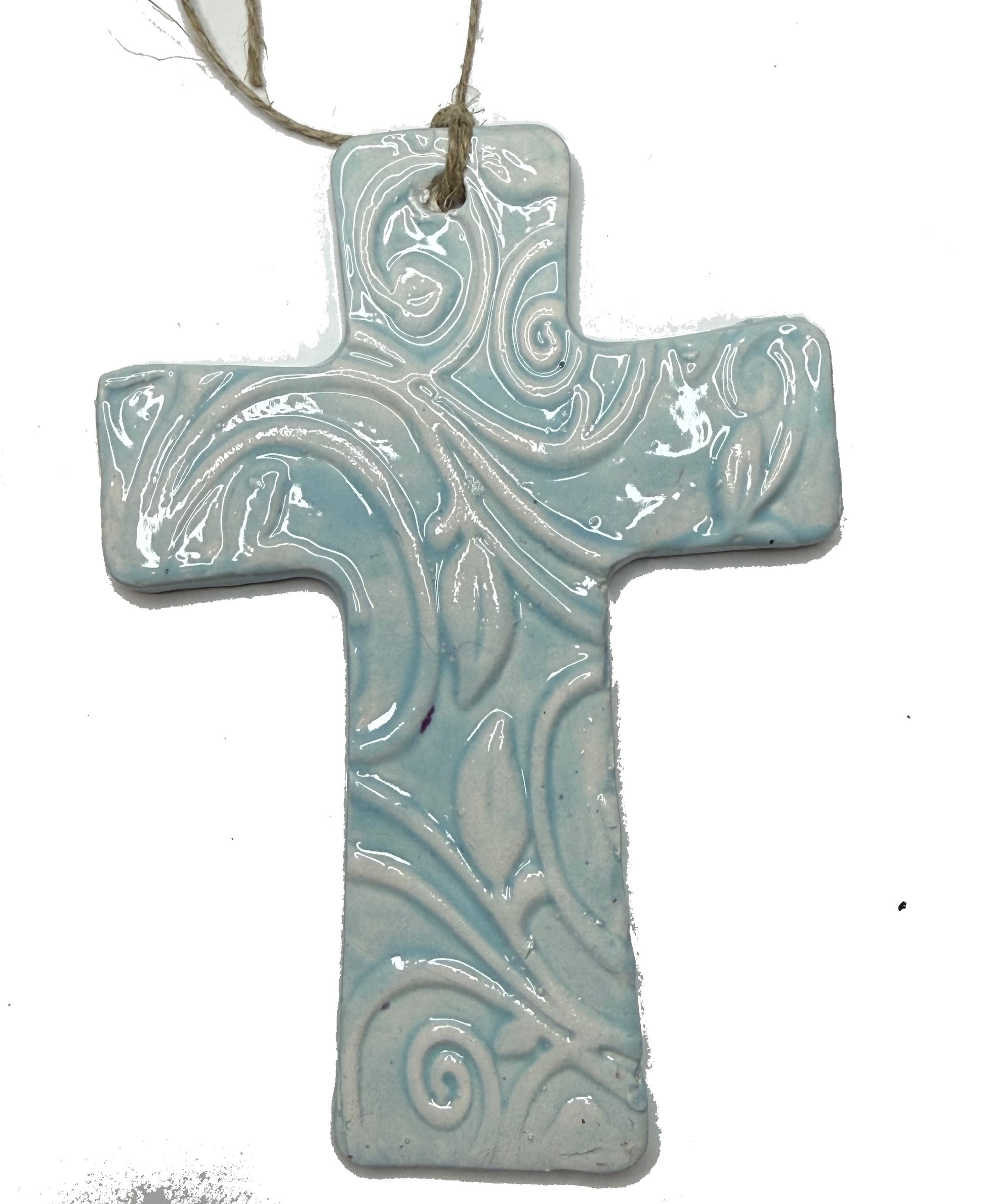 Light blue ceramic cross sculpture by Lorena Williams with smooth finish and detailed design, ideal for home decor or spiritual space.