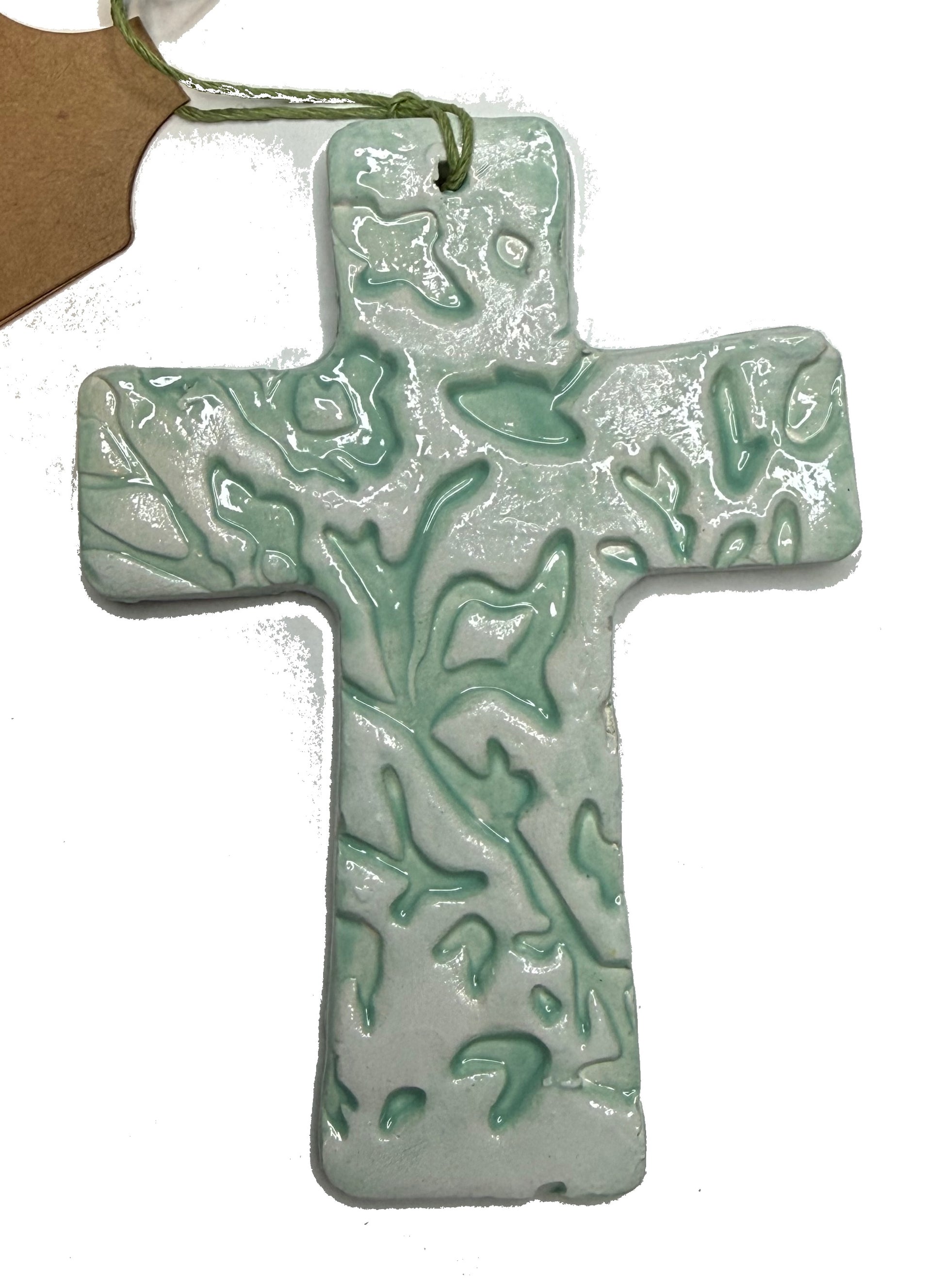 Light teal ceramic cross by Lorena Williams, featuring a smooth finish and decorative design, suitable for wall decor.