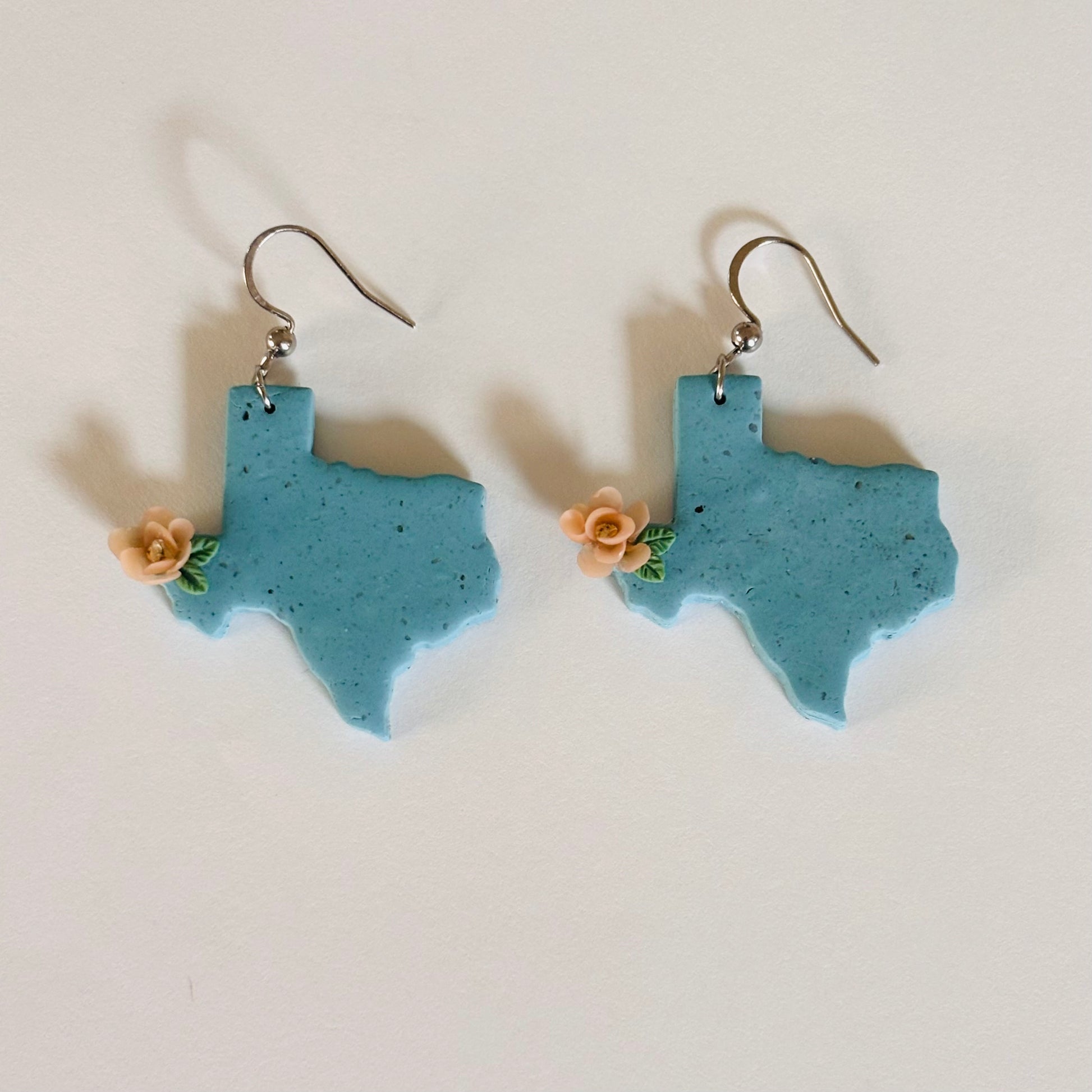Colorful Texas polymer clay earrings from Ysleta Mission Gift Shop, featuring intricate Native American-inspired designs.