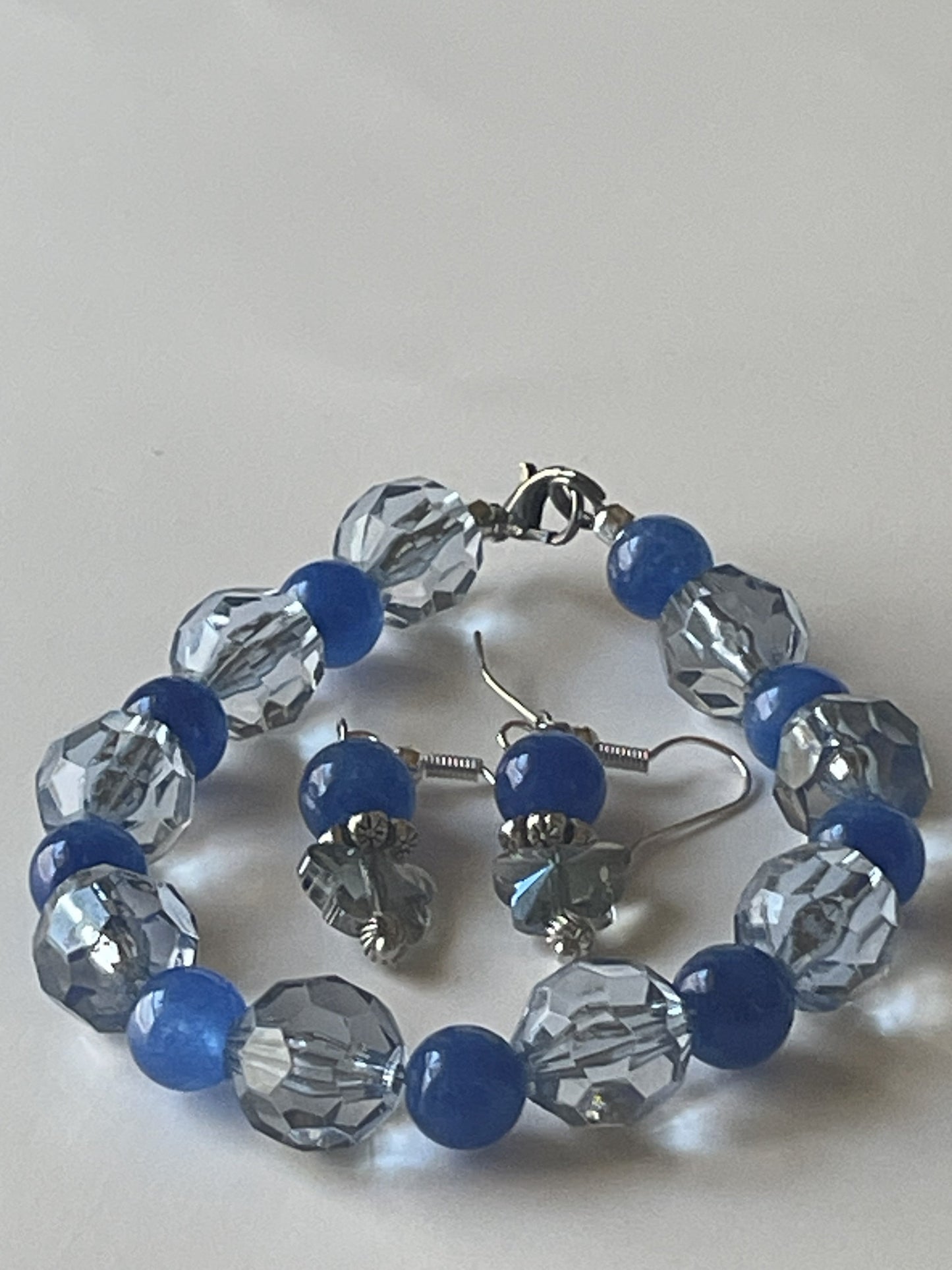 Sylvia Leroux 7-inch bracelet with 8mm blue Kyanite beads, matching light blue faceted earrings, silver spacers, lobster clasp, and ear hooks.