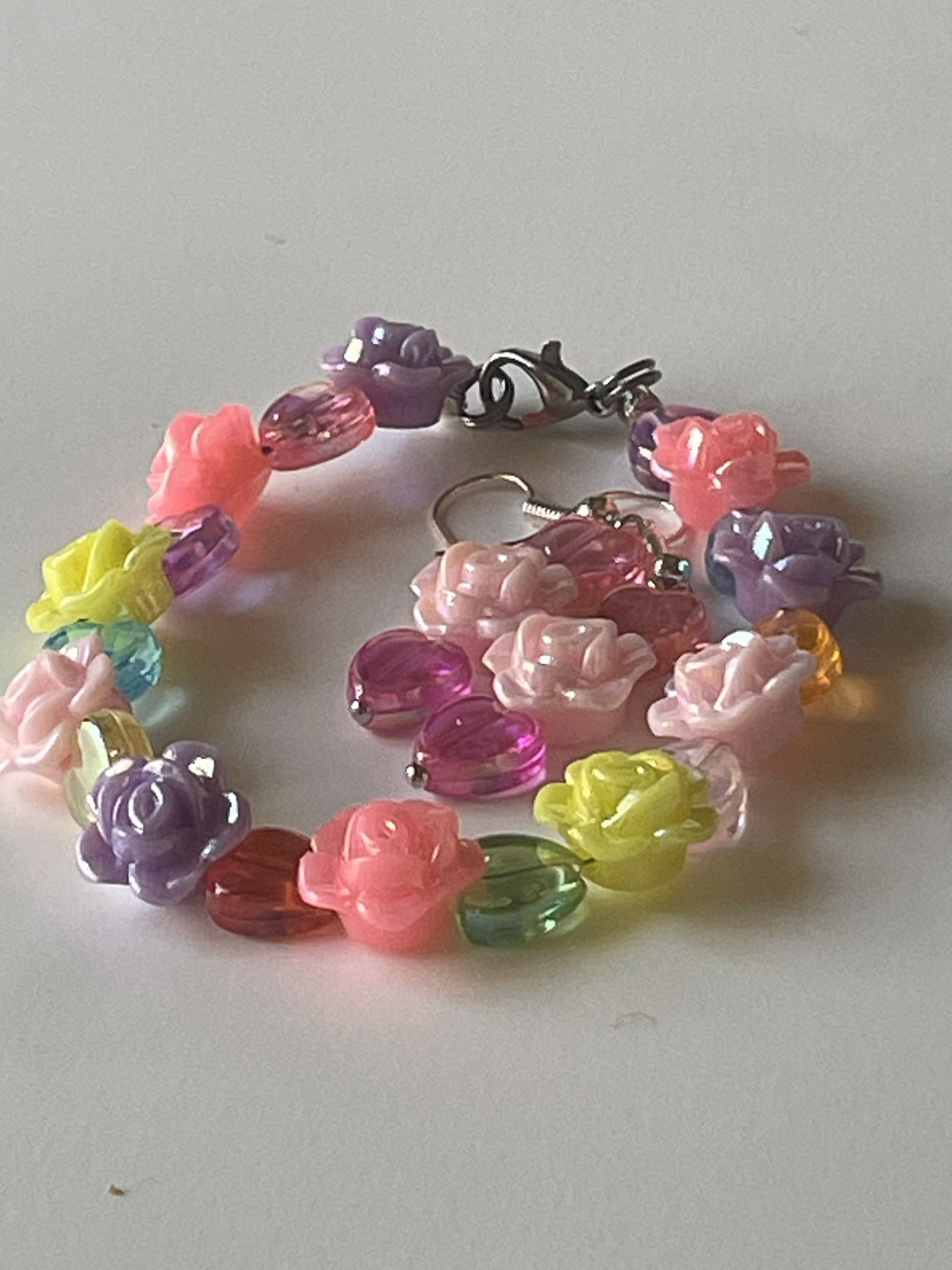 Pastel rose and clear heart resin jewelry set with 7-inch bracelet and matching 2-inch dangle earrings, silver lobster clasp and hooks.