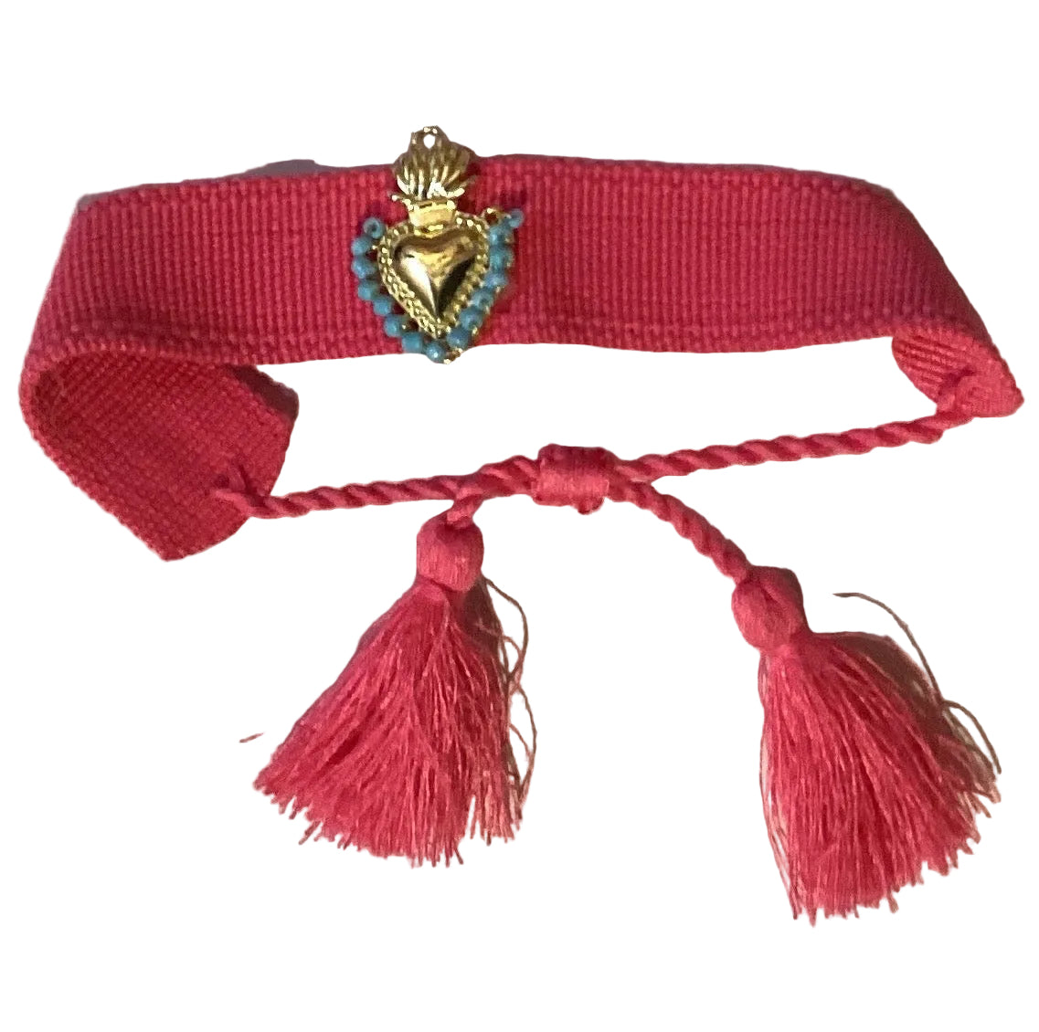 Pink woven Sacred Heart bracelet with hand-beaded centerpiece, tassel ends, blue beads, and adjustable cord, by Ysleta Mission Gift Shop.