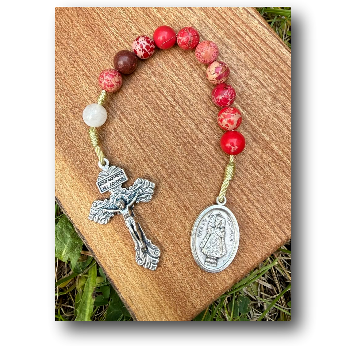 Infant of Prague Catholic rosary with red imperial jasper and white jade beads, featuring a small crucifix and medallion.
