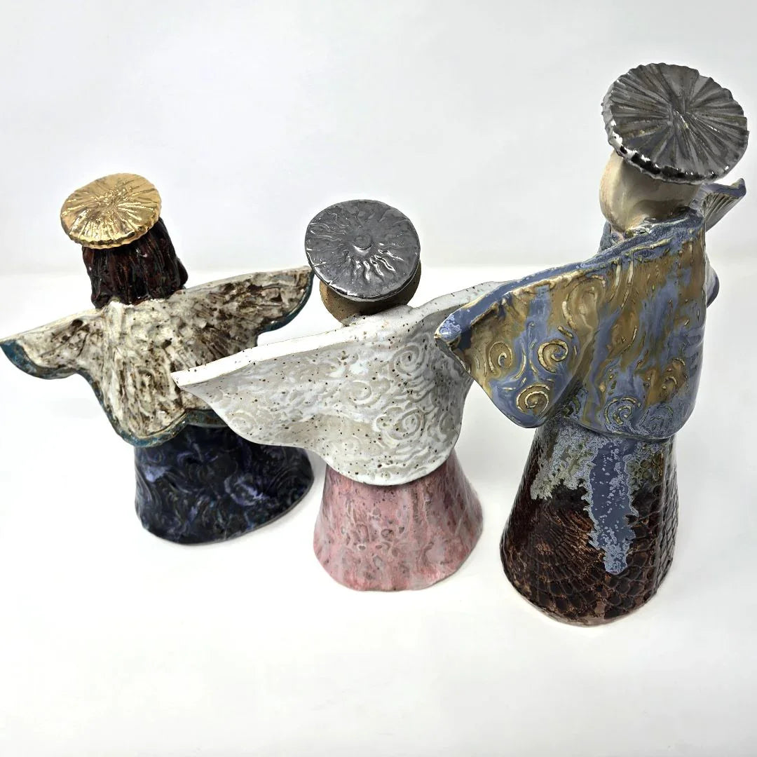 Ceramic angel sculpture with a metallic halo, minimalist design, by Vanessa Clark, depicting a serene religious figurine.