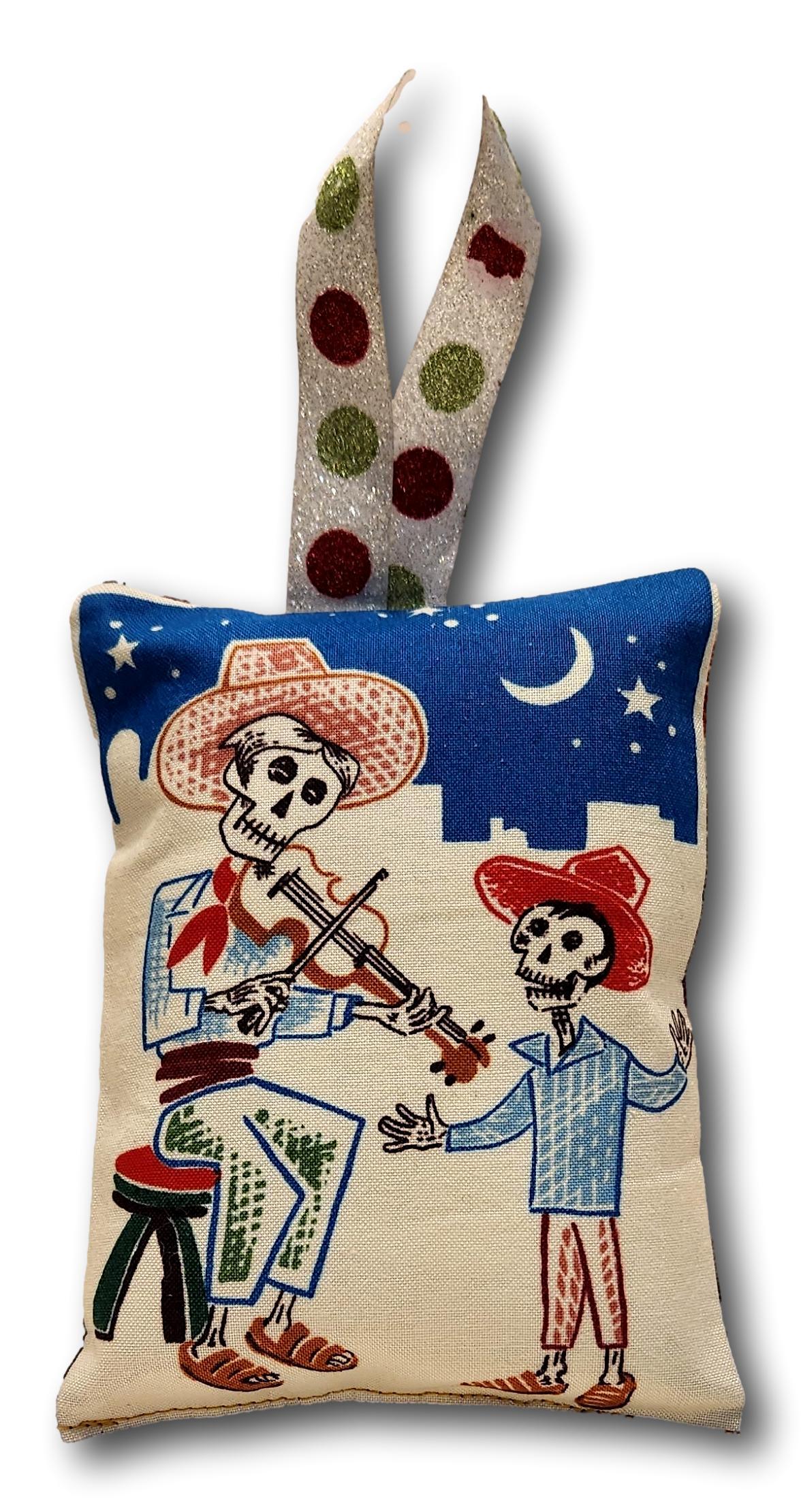 Decorative cotton pillow ornament with Day of the Dead theme, featuring various colorful designs, 5x4 inches, from Ysleta Mission Gift Shop.