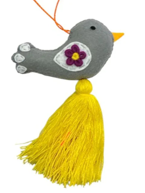 Colorful embroidered bird charm by Jose Alberto Chavez on a handmade bag or car accessory, showcasing vibrant, detailed needlework.