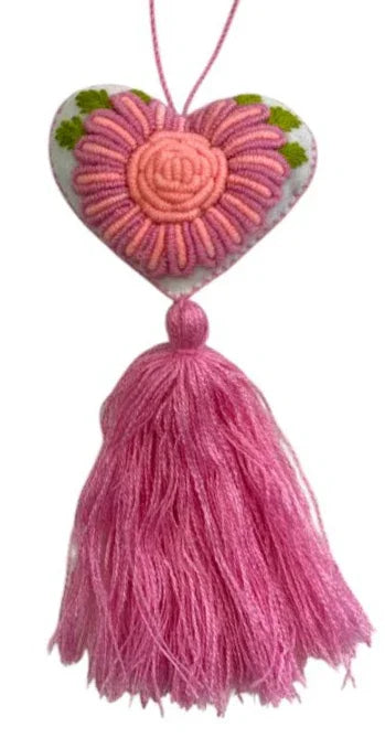 Handmade Mexican textile embroidered heart charm attached to a bag accessory by Jose Alberto Chavez, featuring colorful traditional embroidery.