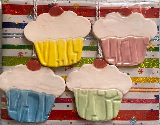 Set of four handmade ceramic cupcake ornaments by Lorena Williams, perfect for bakers and home decor.