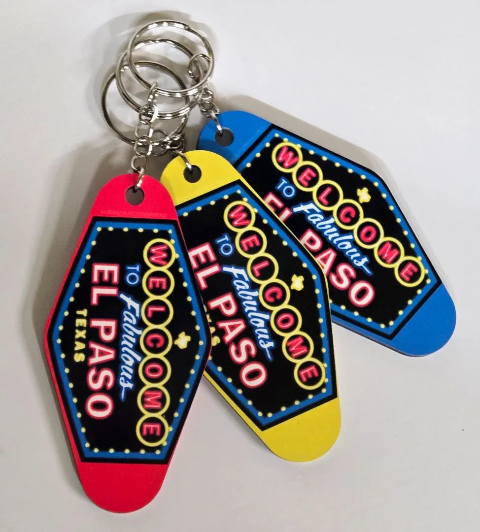 El Paso souvenir keychain featuring a neon-style "Welcome to El Paso" motel sign, double-sided sublimated design by Vanessa Clark.