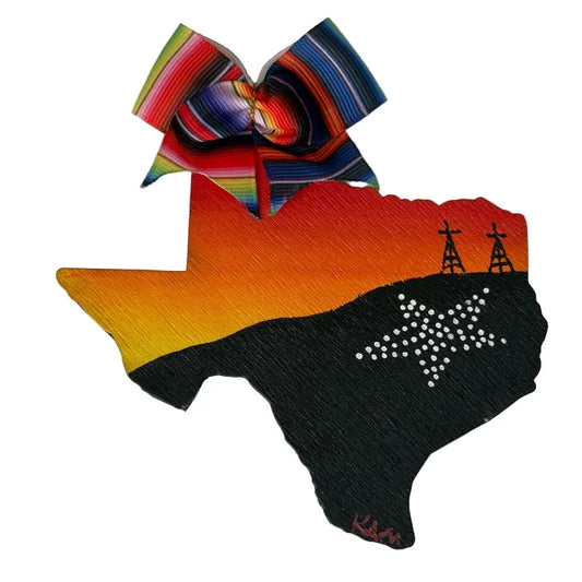 Hand-painted orange El Paso Texas-shaped magnet featuring a desert sky motif, serape ribbon, and wooden souvenir from Krystal Molina.
