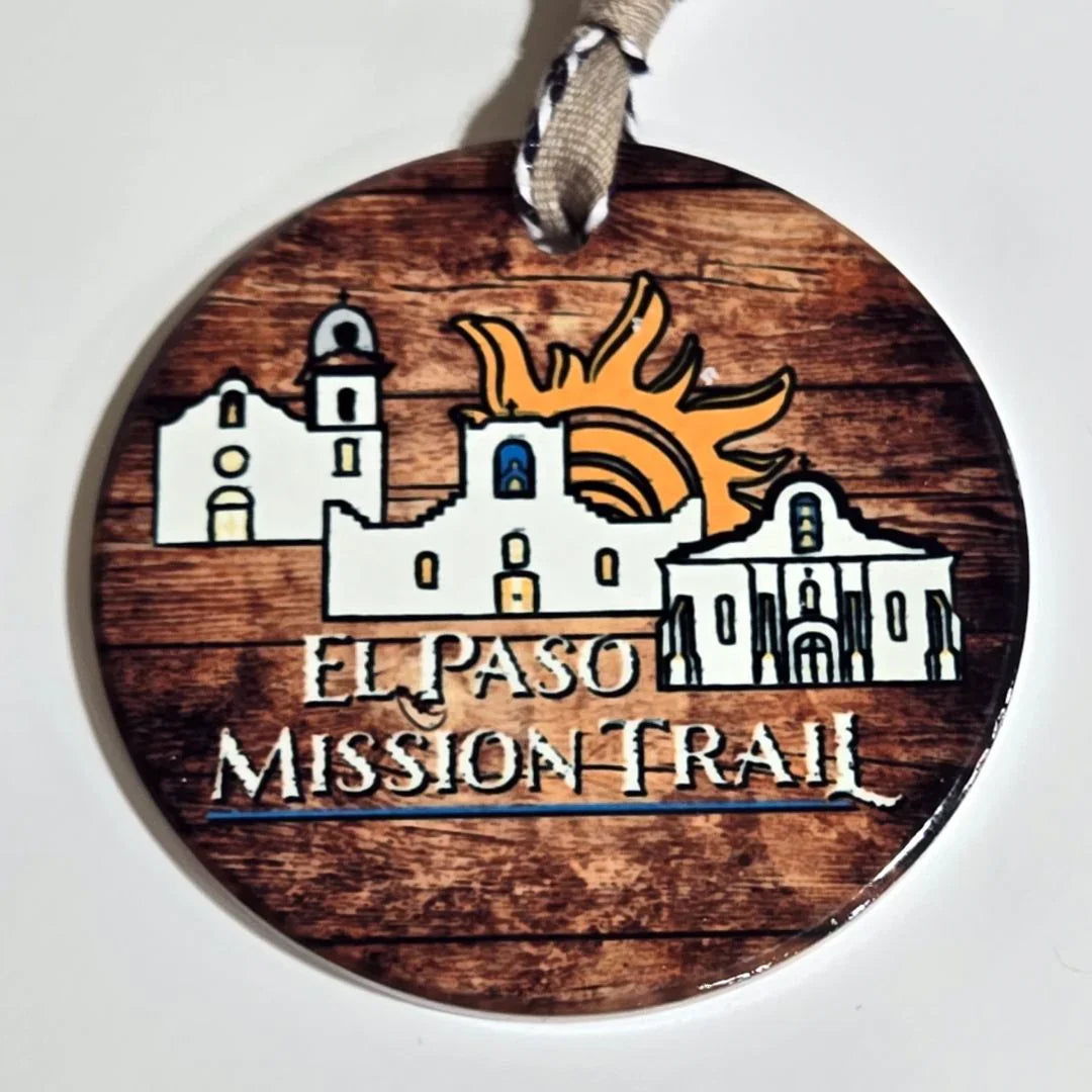Colorful ceramic Christmas ornament featuring El Paso Mission Trail artwork, with vibrant ribbon design by Vanessa Clark.