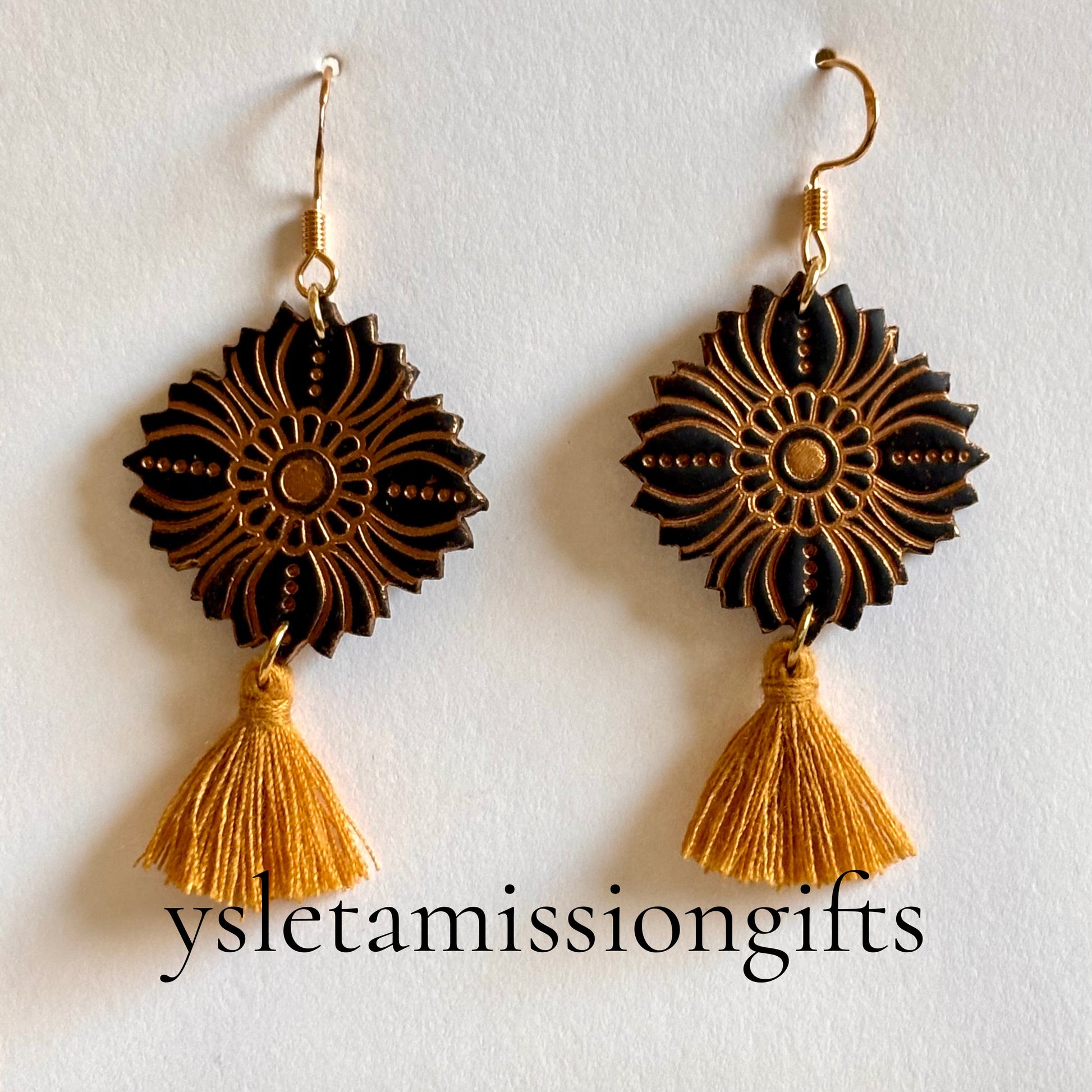 Black and gold polymer clay Talavera dangle earrings by Melissa Cortinas, featuring intricate, colorful patterns in a jewelry design.