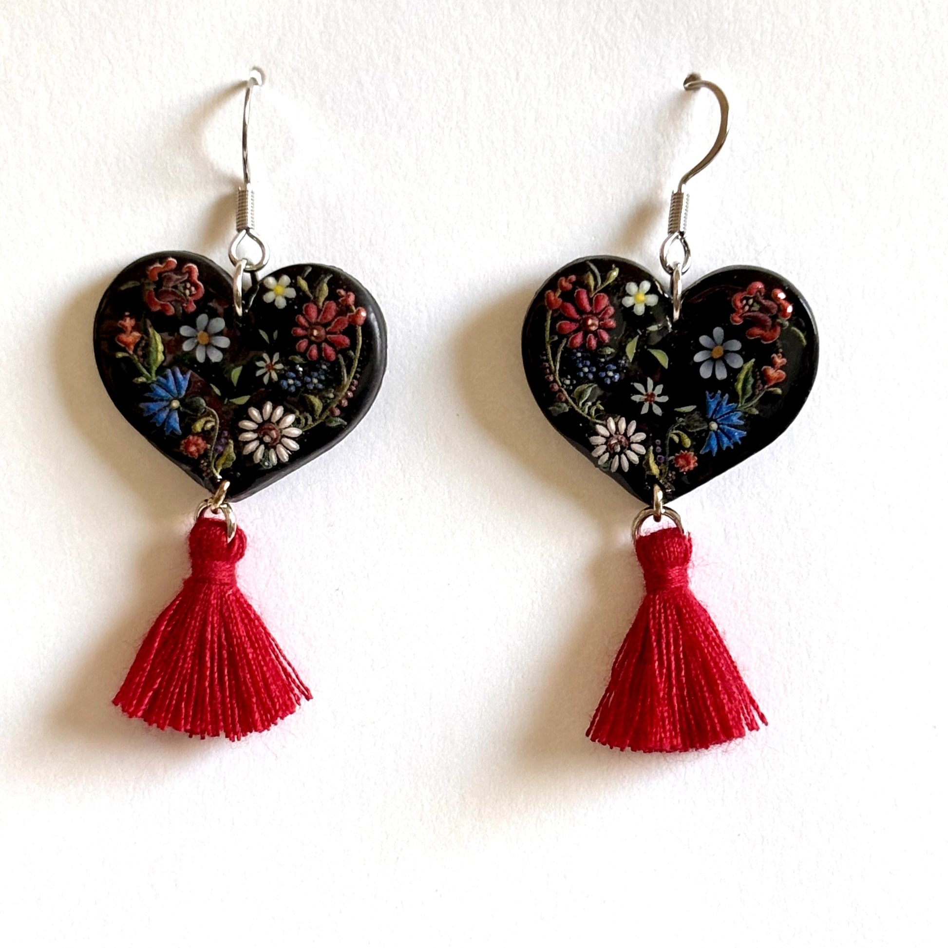 Polymer clay black and red floral heart dangle earrings by Melissa Cortinas, featuring intricate floral designs and dangling style.