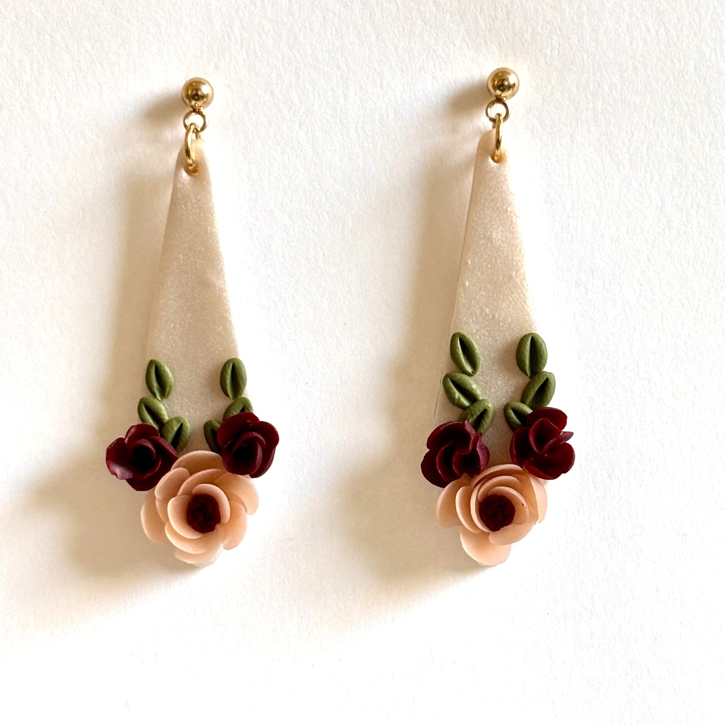 Polymer clay crimson floral dangle earrings by Melissa Cortinas featuring intricate flower designs and elegant craftsmanship.