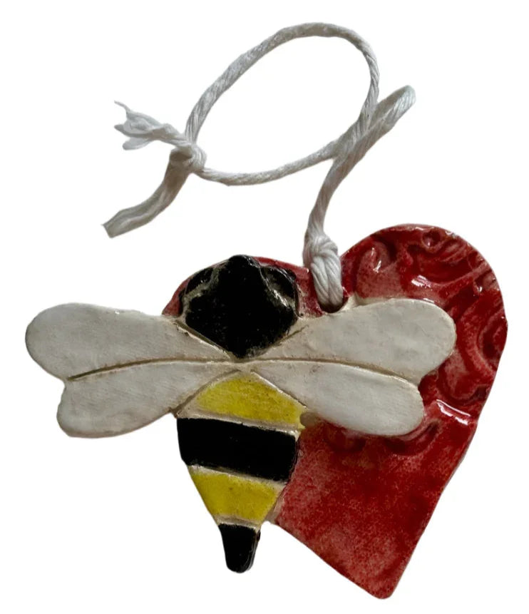 Handmade red ceramic heart wall decor with a bumble bee accent, crafted by Lorena Williams, glazed for a glossy finish.