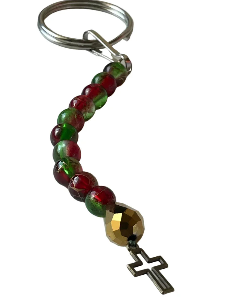 Red and green beaded keychain with bronze cross and 4-inch rosary cord by Sylvia Leroux for bag accessories.