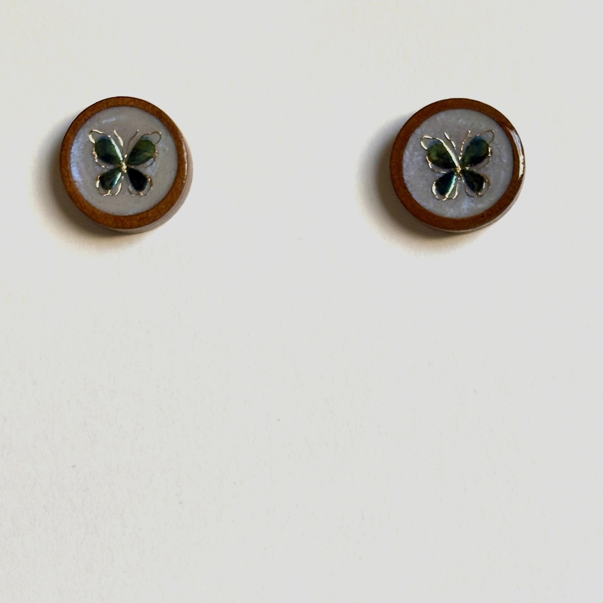 Resin wood cabochon butterfly stud earrings by Melissa Cortinas, showcasing handcrafted jewelry with colorful butterfly designs.